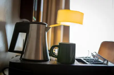 a coffee pot and a cup on a table at Hotel Atlantic Agdal in Rabat