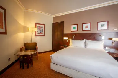 a hotel room with a large bed and a table at Hotel Atlantic Agdal in Rabat