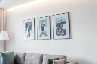 four framed pictures on a wall above a couch at Makass Appart Hotel in Rabat
