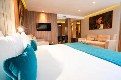 a hotel room with a bed and a living room at First Suites Hôtel in Rabat