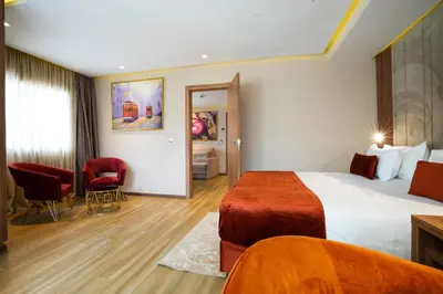 a hotel room with a bed and a living room at First Suites Hôtel in Rabat