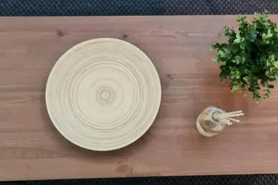 a white plate on a wooden table with a plant at Très bel appartement en face du parc, près du Novotel in Mohammedia