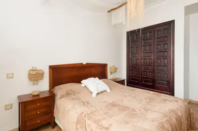 a bedroom with a large bed and a wooden door at Sea view Tamaris Dar Bouazza in Tamaris