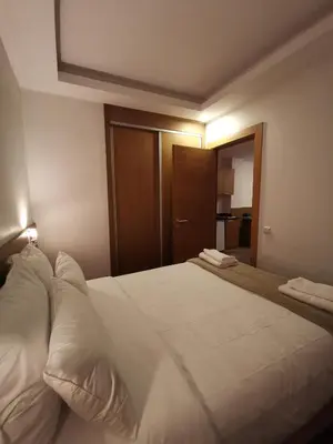a bedroom with a large bed with white sheets at Casa City Break Appart hôtel in Casablanca