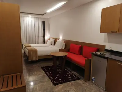 a hotel room with a bed and a red couch at Casa City Break Appart hôtel in Casablanca