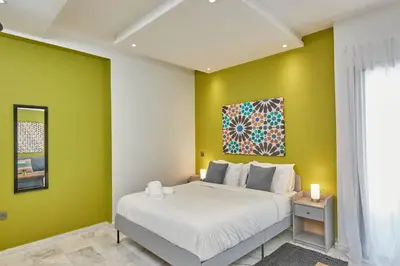 a bedroom with a white bed and yellow walls at Stayhere Rabat - Agdal 2 - Classic Residence in Rabat