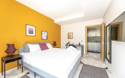 a bedroom with a white bed and a yellow wall at Stayhere Rabat - Agdal 2 - Classic Residence in Rabat