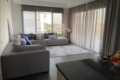 a living room with a couch and a large window at Appt BOUZNIKA EDEN ISLAND pied sur Mer pour FAMILLE et Couple MARIE in Bouznika