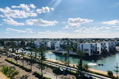 arial view of a city with a river and buildings at Eden Island Apartment with a View in Sidi el Haj Bou Derbala