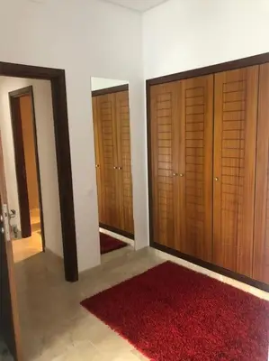 a room with three wooden doors and a red rug at 5 Star Apartment Near Airport in Nouaseur