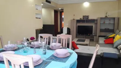 a table with a blue table cloth and chairs in a living room at Apartment with Terrace in Casablanca