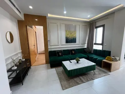 a living room with a green couch and a table at Luxury appartement in Heart of Casablanca Maarif in Casablanca