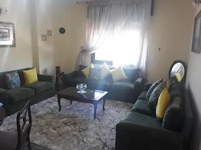 a living room with couches and a table and a window at Maison vintage Rabat Agdal in Rabat