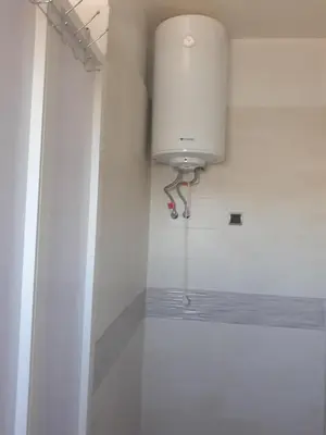 a white bathroom with a water tank on the wall at Maison vintage Rabat Agdal in Rabat