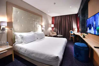 a hotel room with a large bed and a desk at Flower Town Hotel & Spa in Rabat