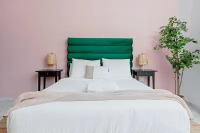 a large bed with a green headboard in a bedroom at Stayhere Rabat - Agdal 1 - Comfort Residence in Rabat