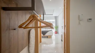 a wooden coat rack hanging on a wall in a room at Stayhere Rabat - Agdal 1 - Comfort Residence in Rabat