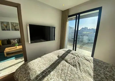 a bedroom with a bed and a flat screen tv at Amazing Flat in Gauthier - Breathtaking View - Best Location in Casablanca