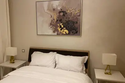 a bedroom with a bed with two nightstands and two lamps at Du Haut Standing au coeur du Parc et Plage à 180 m in Mohammedia