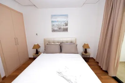 a bedroom with a white bed and two lamps at Prestigia Rabat Hay Riad Premium Apartments in Rabat