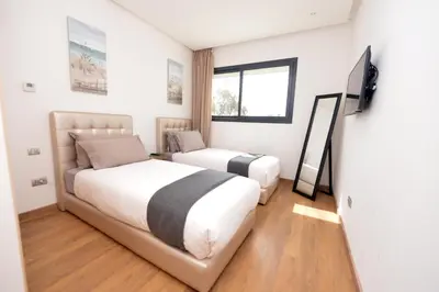 a bedroom with a bed and a tv in it at Prestigia Rabat Hay Riad Premium Apartments in Rabat