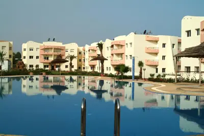 a large swimming pool in front of some buildings at Mohammedia appart piscines in Mohammedia