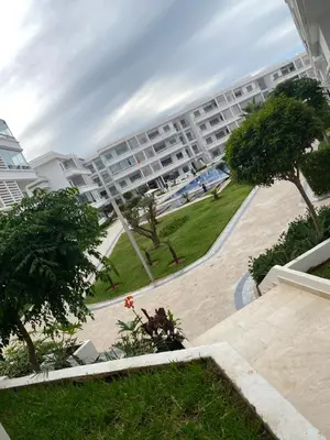 a large apartment building with a park in front of it at Mansbay Beach, Vue sur Mer, accès Plage à pied, Mohammedia in Mohammedia