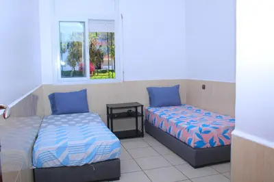 a bedroom with two beds and a window at L Appartement évasion in Mohammedia
