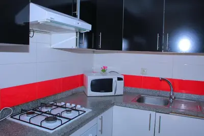 a kitchen with a stove and a microwave at Les charmes de la Campagne de Bouznika in Bouznika