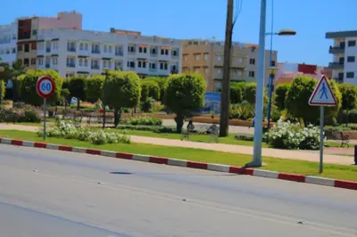 an empty street with buildings in the background at Les charmes de la Campagne de Bouznika in Bouznika