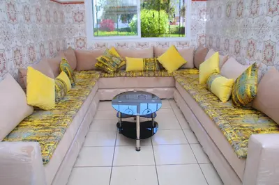 a couch with pillows and a table on it at Mohammedia pour les vacances in Mohammedia