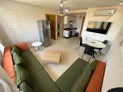 a living room with a green couch and a table at CASA BEACH HOTEL in Sidi Rahal