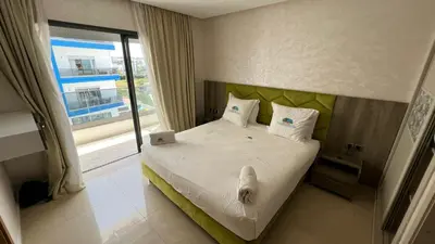 a bedroom with a bed with a laptop on it at CASA BEACH HOTEL in Sidi Rahal