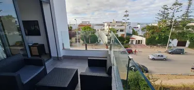 a balcony with benches and a view of a parking lot at Appartement neuf haut standing vue mer in Skhirat