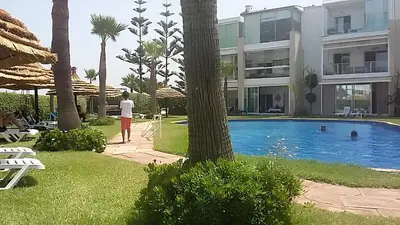 a person standing near a swimming pool in a resort at Appartement au Bord de la Mer in Casablanca