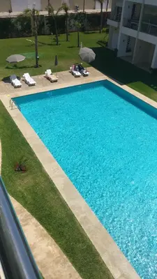 an overhead view of a swimming pool with chairs and umbrellas at Casabay Appart Vue Sur Piscine in Sidi Rahal