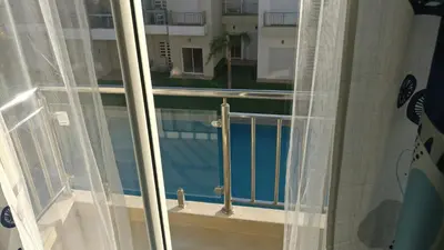 a window with a view of a swimming pool at Casabay Appart Vue Sur Piscine in Sidi Rahal
