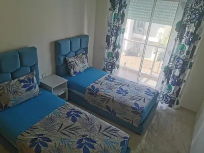 a bedroom with two beds and a window at Casabay Appart Vue Sur Piscine in Sidi Rahal