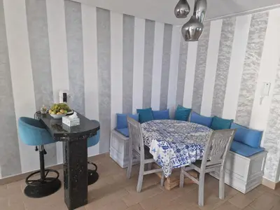 a dining room with a table and blue chairs at La petite villa avec piscine pieds dans l'eau in Sidi Rahal