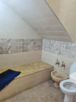 a bathroom with a bath tub and a toilet at La petite villa avec piscine pieds dans l'eau in Sidi Rahal
