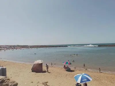 a group of people on a beach with umbrellas at Maison Etoile De Mer 1 in Skhirat