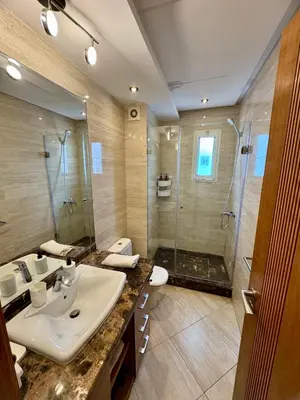 a bathroom with a sink and a shower at Peninsula Dar Bouazza Superbe appartement en résidence avec piscine activités in Dar Bouazza
