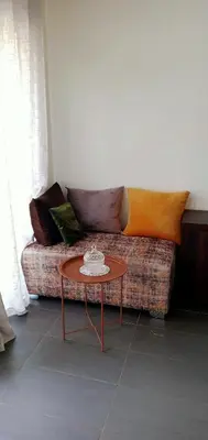 a couch with pillows and a table in a room at Appartement Familial avec Jardin, Résidence avec Piscine Dar El Bahr in Sidi Rahal