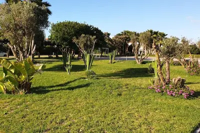 a park with trees and flowers in the grass at Appartement Familial avec Jardin, Résidence avec Piscine Dar El Bahr in Sidi Rahal