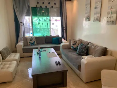 a living room with two couches and a coffee table at A 5 minutes à pied de la plage un bel appartement à saisir in Sidi Rahal