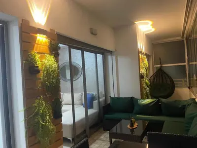 a living room with a couch and some plants at Très bel appartement neuf à Mansbay Manssouria in Mohammedia