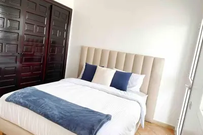 a bedroom with a large bed with blue and white pillows at Appartement vue mer panoramique in Tamaris
