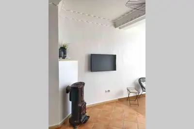 a living room with a tv on a white wall at Appartement vue mer panoramique in Tamaris