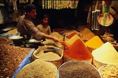 a man and a child in a market with spices at Beautiful apart Agdal in Rabat