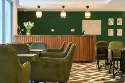 a waiting room with chairs and a green wall at BH Appart Hotel in Casablanca